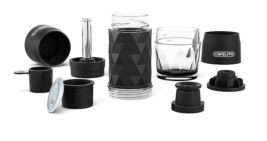 Hiker holding Dejess portable hand press espresso maker on mountain trail outdoor adventure