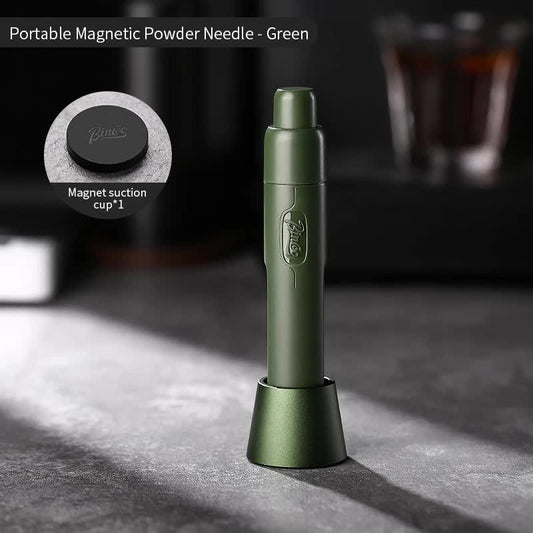 Dejess green telescopic magnetic WDT tool with stainless steel needles resting beside a portafilter on an espresso bar