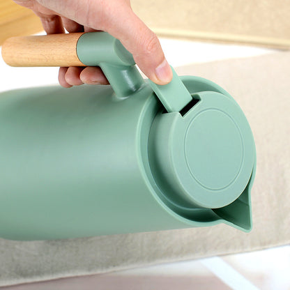 Wooden handle thermos bottle 1000ml pouring hot coffee into ceramic mug